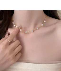 Close-up view of an elegant double-strand pearl necklace with 18k gold plated beads on neck