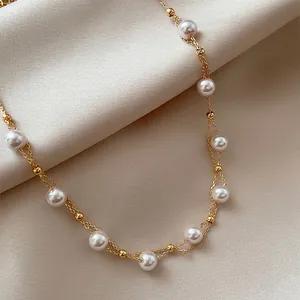 Close-up detail of the 18k gold plated chain and lustrous white pearls necklace