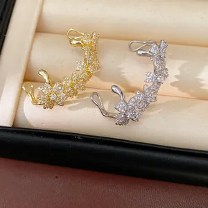 Gedetailleerd overzicht van met zirkoon ingezette bloem oorclips in goud en zilver.
