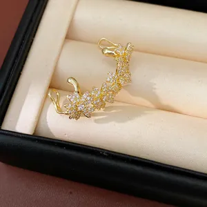 Detailopname van een 14k vergulde bloemenoorklem bezet met schitterende zirkonia's