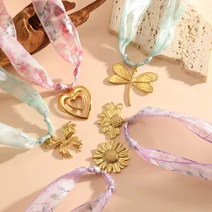 Collection of stainless steel heart, flower and dragonfly pendants on silk ribbon necklaces.