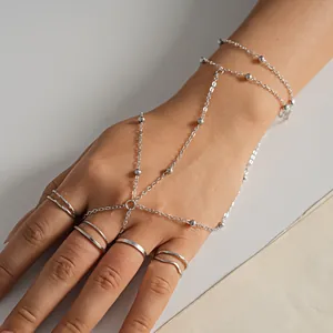 Vista dettagliata di una catena per mano in argento multistrato con perline e anelli coordinati.