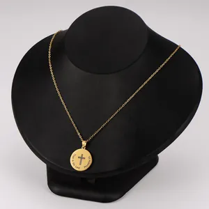Detalle de un collar de acero chapado en oro con cruz grabada y versículo bíblico.