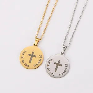 Primer plano de colgantes de cruz 'Trust in the Lord' grabados con láser en oro y plata