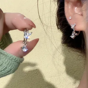 Close-up detail of elegant silver butterfly hoop earrings with sparkling zircon drop charms