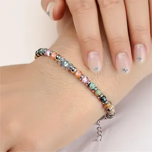 Detailed view of a 4mm African pine and moonstone beaded stainless steel bracelet.