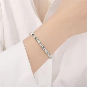Detail view of 4mm African pine and moonstone beaded bracelet on wrist