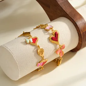 Vista dettagliata del bracciale in acciaio inossidabile dorato con ciondoli a cuore e fiocco