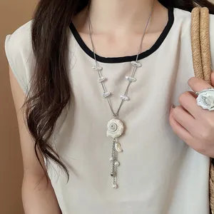 Close-up of elegant conch pearl necklace and flower ring set for summer beach vacation