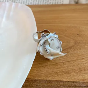 Macro view of seashell flower ring with crystals, island style summer jewelry.