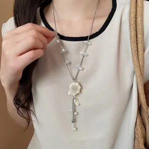 Detail of island style seashell pearl necklace on model for summer beach vacation