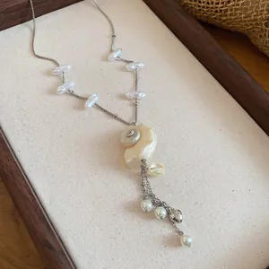 Detail view of summer beach vacation necklace with seashell pendant and baroque pearls
