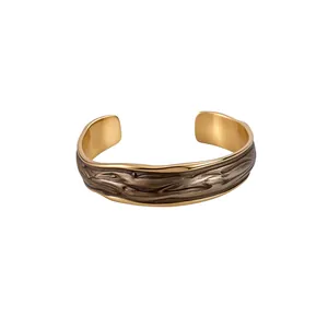 Bracciale rigido aperto dorato con texture vintage e design a goccia d'olio elegante