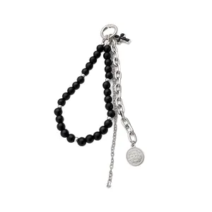 Fashionable black beaded keychain with silver chain, cross charm, and vintage coin pendant