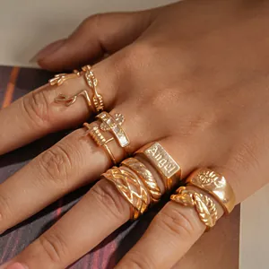 Close-up of vintage gold rings with leaf, antler, and Angel engravings on fingers