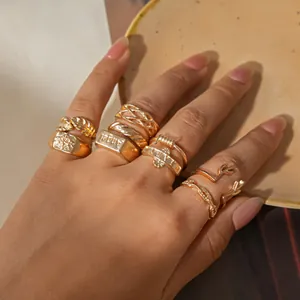 Detail of a vintage gold-toned ring set featuring leaf and antler designs on a hand.
