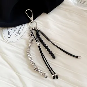 Detailed macro view showing the textured black beads and metallic silver elements