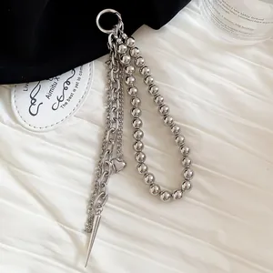 Detail view of silver multi-layered beaded keychain accessory with heart and spike pendant
