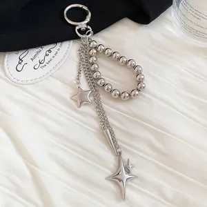 Close-up of a silver-toned metal beaded keychain featuring star charms and dangling chains