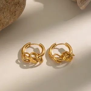 Dettaglio di orecchini a cerchio minimalisti in acciaio inossidabile dorato 18K.