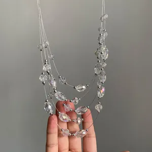 Detalle de un collar multicapa de cuentas de vidrio transparente y espaciadores