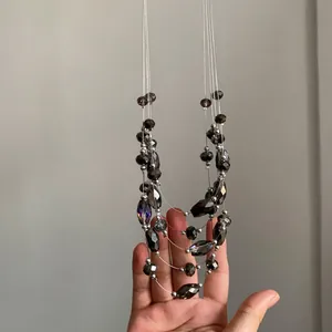 Primer plano detallado de un collar de cuentas de vidrio multicapa con acabado brillante