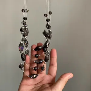 Detalle de collar multicapa con cuentas de vidrio facetado en color gris ahumado