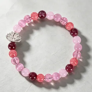 Macro detail of natural pink strawberry quartz beads with a delicate silver lotus charm