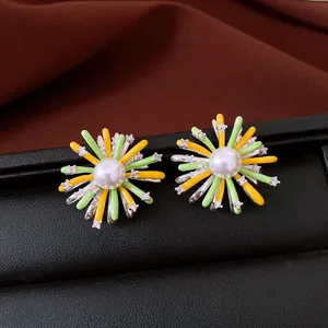 Nahaufnahme von bunten Emaille-Blumenohrringen mit Perlenzentren und Zirkonia-Steinen