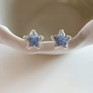 Close-up of sparkling blue crystal star stud earrings in a elegant silver frame
