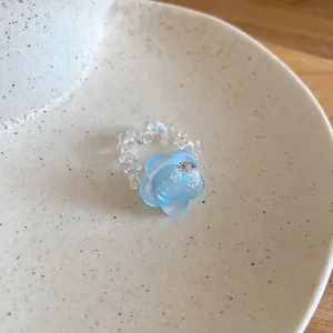 Vista dettagliata di un anello in perle di cristallo con ciondolo fiore blu