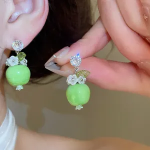 Squisito primo piano di orecchini con perline mela verde, zircone scintillante e ciondoli a fiore