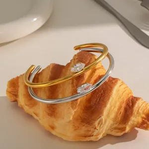 Detail van gouden en zilveren armbanden met marquise geslepen stenen op een croissant