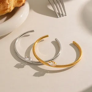 Gedetailleerd overzicht van gouden en zilveren open armbanden met marquise geslepen stenen