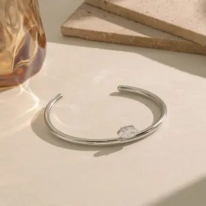 Detail van een zilveren roestvrijstalen open armband met marquise geslepen kristal