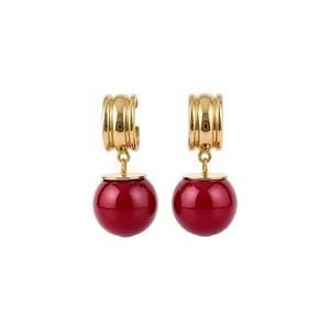 Elegante goudkleurige druppeloorbellen met levendige rode bolvormige harsbedels.