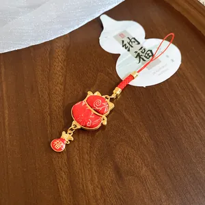 Close-up of a lucky red cat paw charm with a gold-tone frame and small Fu bag.