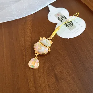 Close-up of exquisite cat paw lucky charm featuring a gold fortune bag pendant charm