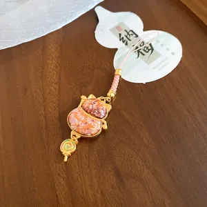Detailed view of a cute cat-shaped fabric ornament featuring a mini lollipop pendant charm