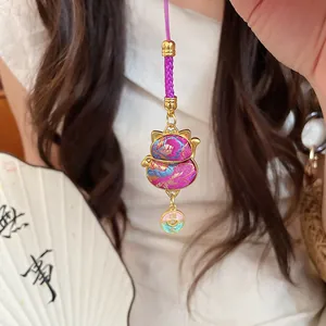 Detailed close-up showing the intricate floral fabric pattern of the lucky cat charm pendant