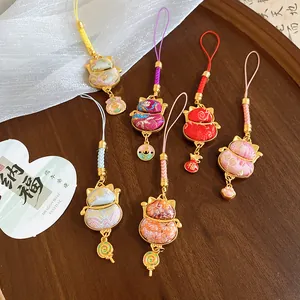 Detail view of colorful embroidered lucky cat pendants with golden frames and cute charms