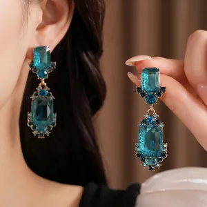 Elegantes pendientes colgantes geométricos de cristal azul vintage con lujoso engaste dorado