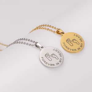 Close-up of stainless steel pendants with engraved footprints and Forever in My Heart text