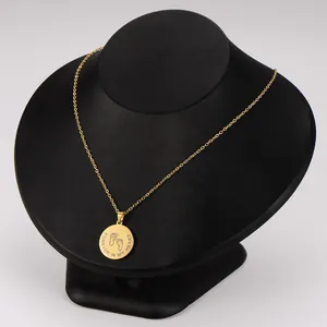 Macro view of gold stainless steel necklace with engraved baby footprints and loving text