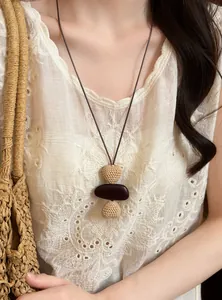 Close-up of vintage ethnic woven long necklace paired with bohemian white lace top