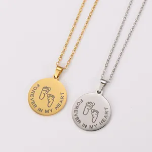 Macro view of gold and silver circular pendants with 'FOREVER IN MY HEART' engraving