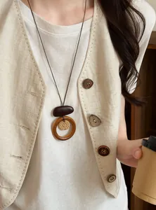Detailed view of a vintage Bohemian long necklace with woven pendant on a model.