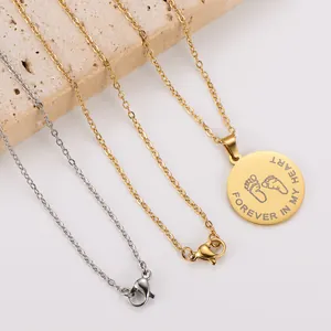 Close-up of gold and silver necklaces with engraved FOREVER IN MY HEART footprint pendant