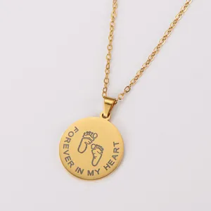 Detailed macro view of the 'Forever in My Heart' engraving on a gold footprint pendant