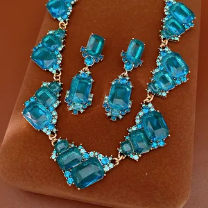 Conjunto de joyas vintage chapado en oro con cristales azules y diseño geométrico.